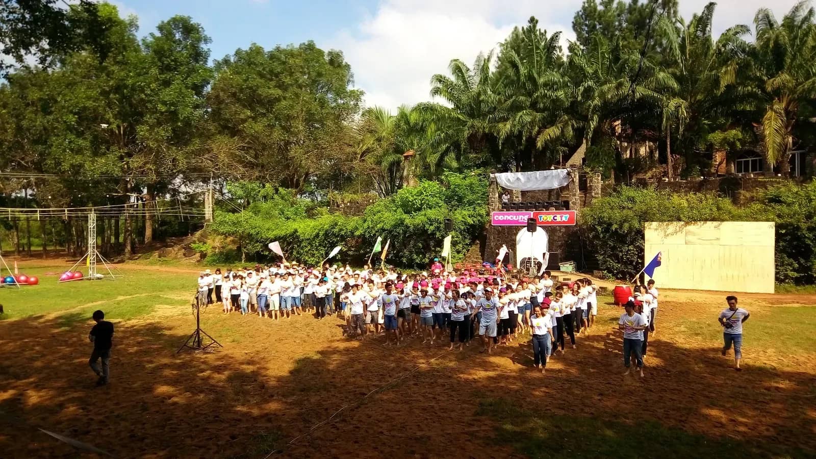 Đoàn học sinh đông người tập trung trên sân cỏ rộng có băng rôn