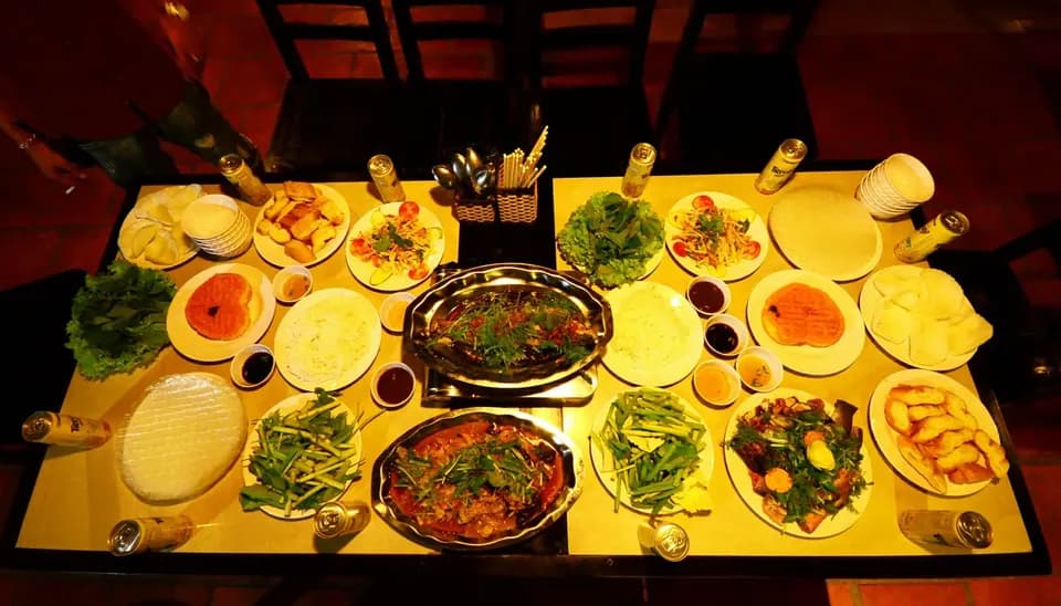 Bàn tiệc bày nhiều món ăn và chén nước chấm