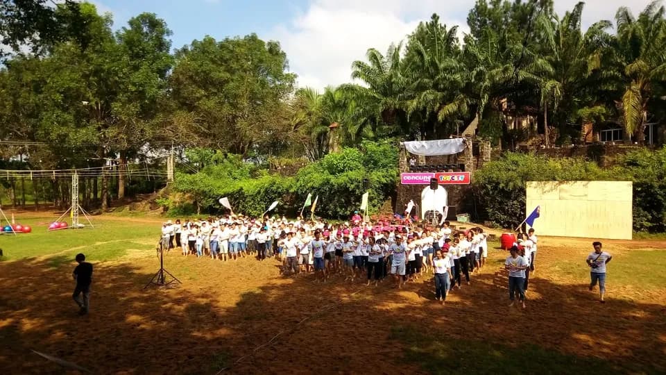Đoàn học sinh đông người tập trung trên sân cỏ rộng có băng rôn