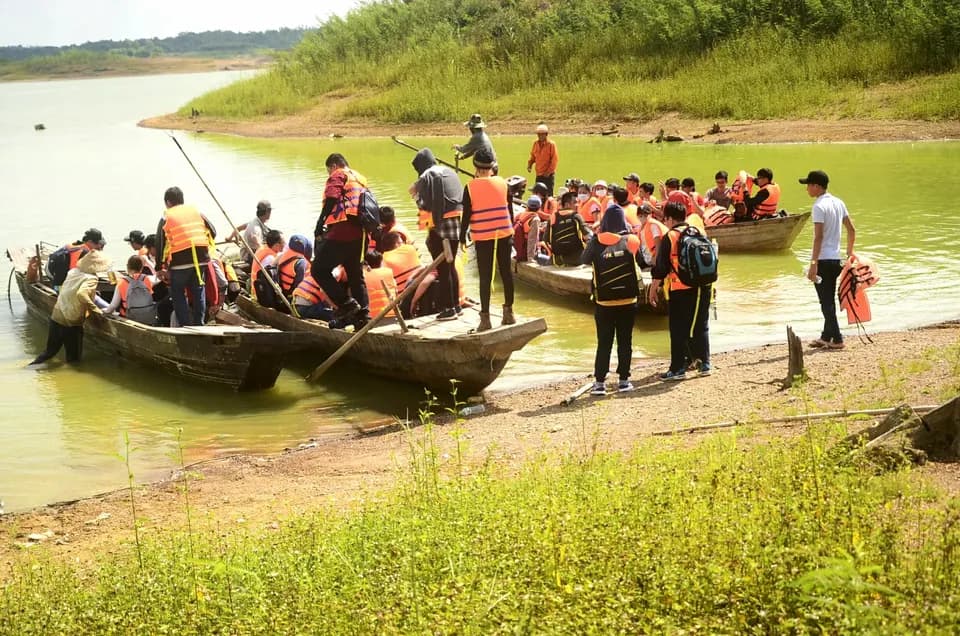 Đoàn khách mặc áo phao lên những chiếc thuyền ven hồ