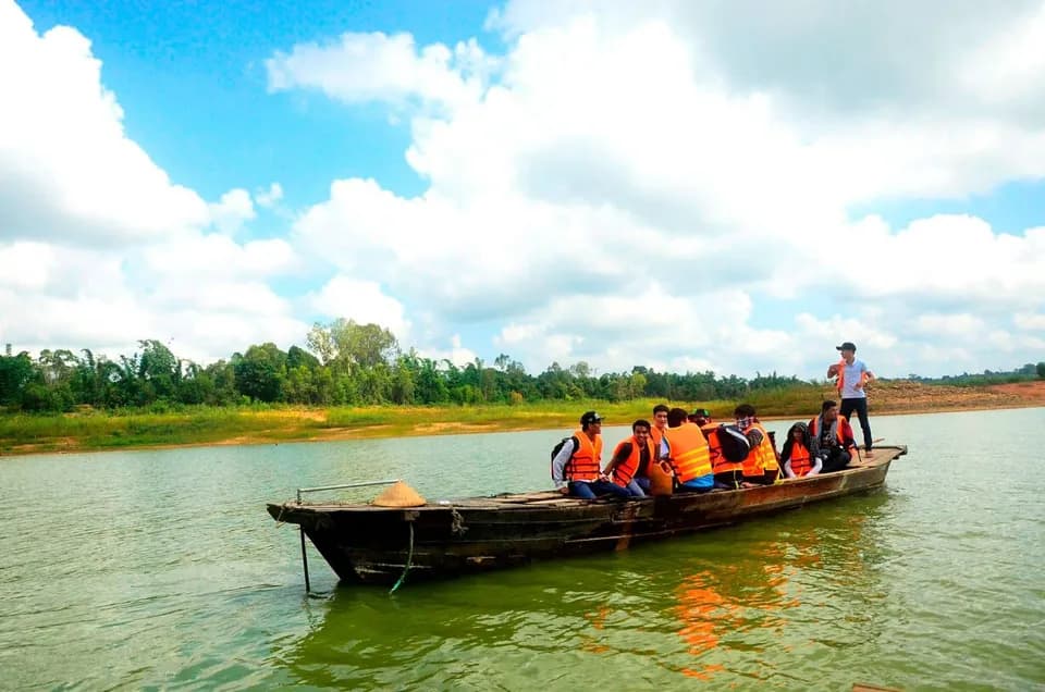 Ghe gỗ chở đoàn khách mặc áo phao trên hồ Trị An