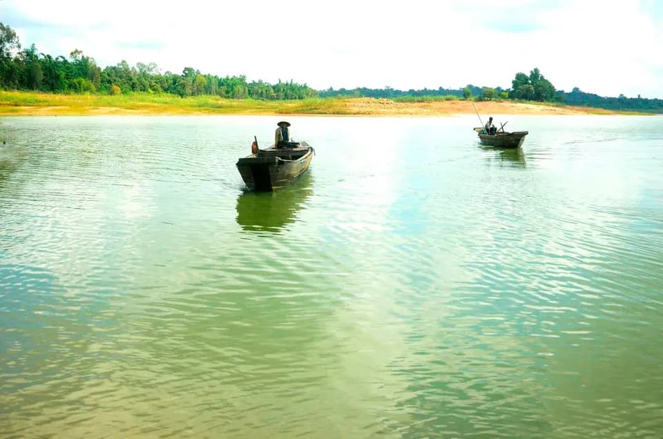 Hai chiếc ghe nhỏ lướt trên mặt hồ Trị An xanh ngọc
