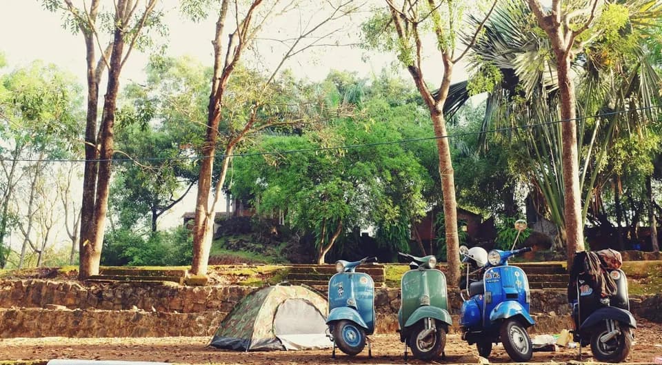 Hàng xe Vespa cổ đậu cạnh lều dưới tán cây