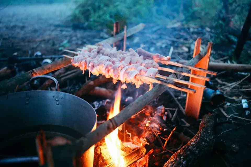 Xiên thịt nướng trên lửa củi giữa trời chạng vạng